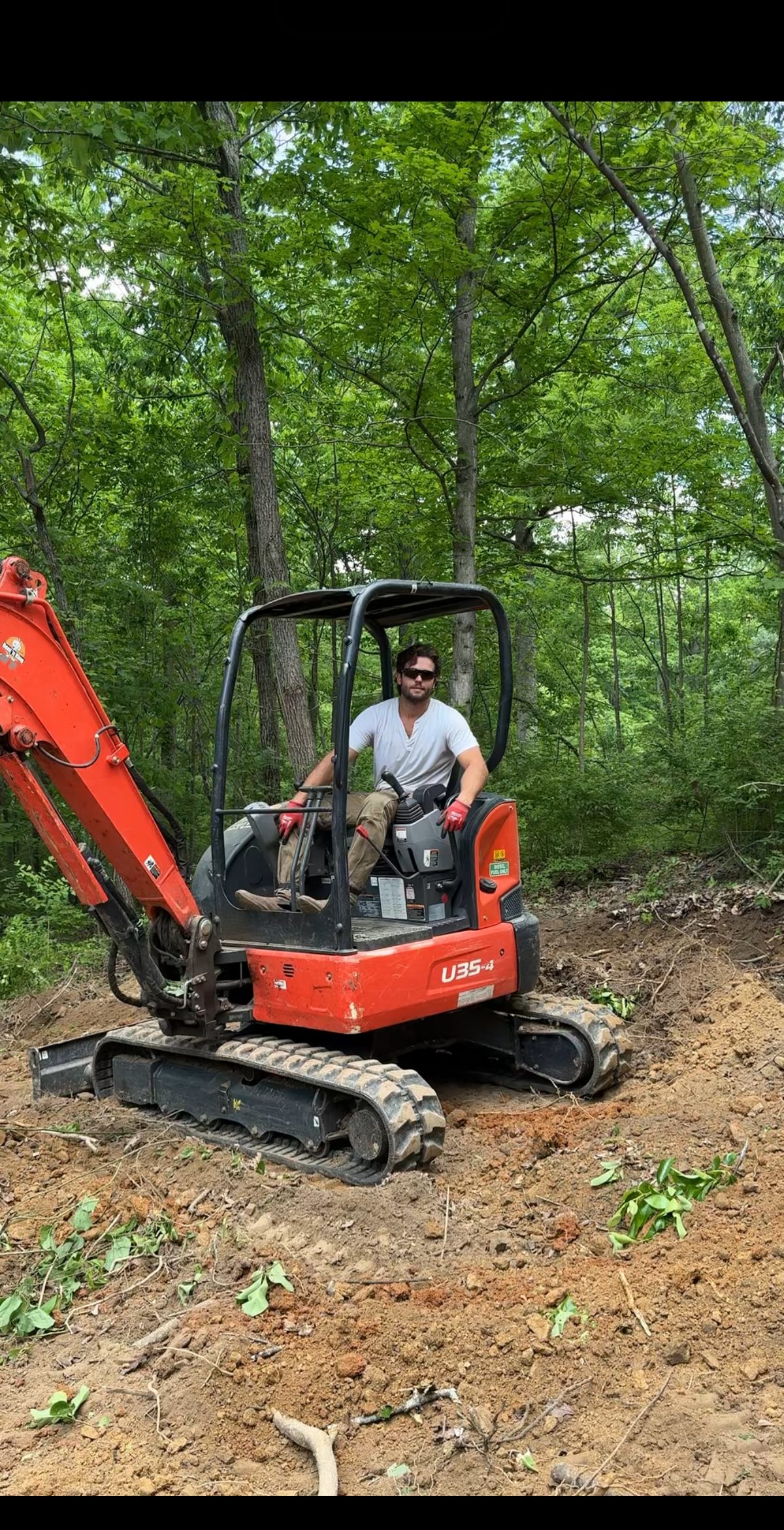 Running the mini excavator to clear the build site